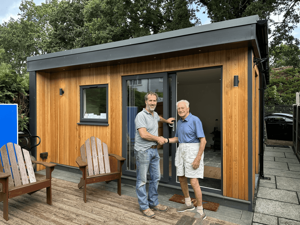 Happy customer shaking hands outside their completed granny annexe in Kent