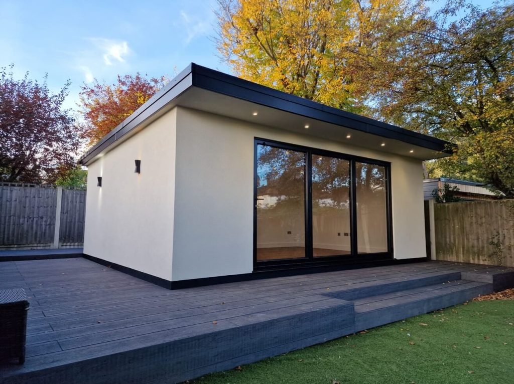 Modern garden room with large windows and deck platform.