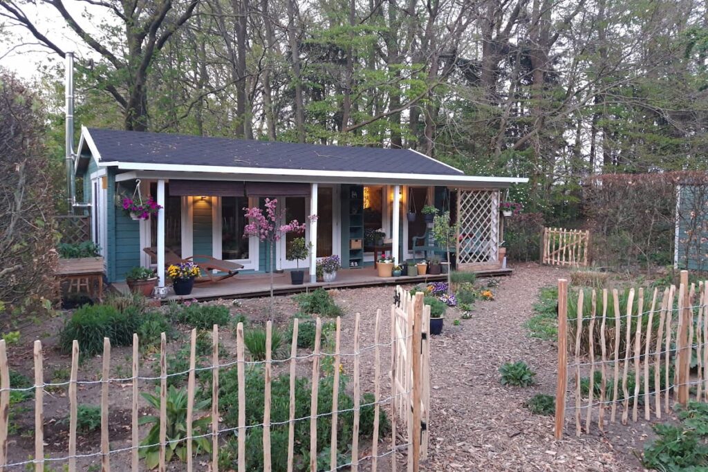 Charming garden granny annexe surrounded by lush greenery and flowers.