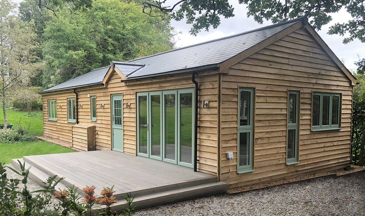 Cozy wooden granny annexe in serene garden setting.